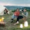 Camping scene with firepit, furniture, and portable lighting