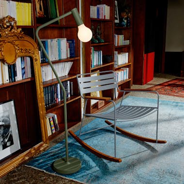 Metal rocking chair with portable lamp and stand in library