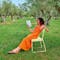 Woman sitting on Bellevie dining chair in olive grove