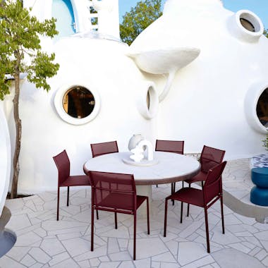 Six Burgundy outdoor chairs around a round white table
