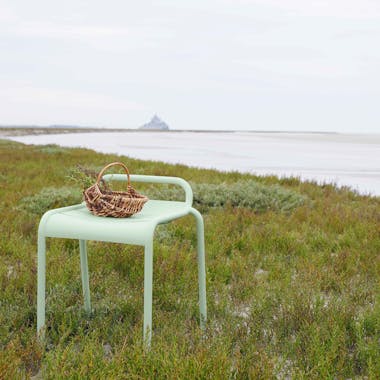 Metal stool on dunes by beach