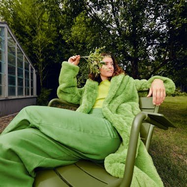 Woman reclining on green outdoor chair