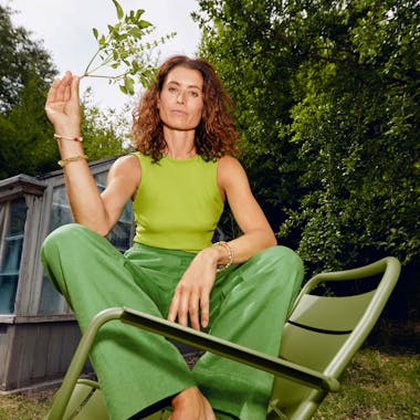Woman sitting on green metal outdoor chair