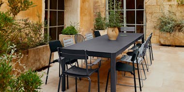 Large outdoor table with a mixture of chairs in blacks and greys