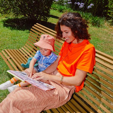 Lady and child sitting reading on a garden bench