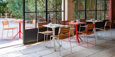 Cafe commercial setting of small table and teak slat chairs in metal