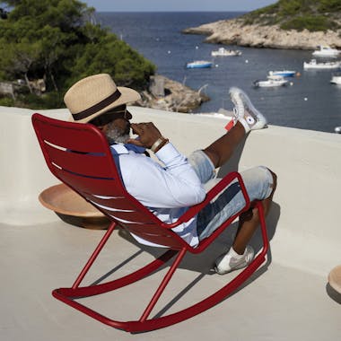 Man relaxing on Luxembourg Rocking Chair overlooking the sea