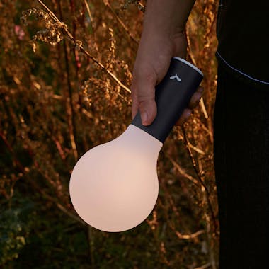 Person holding Aplo lamp in evening light