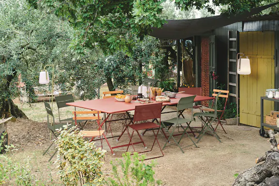 Metal folding outdoor dining table and chairs in a rustic setting