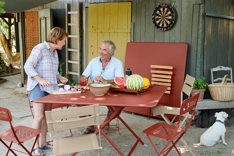 Couple prepare vegetables on an outdoor table