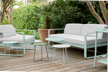 Bellevie outdoor sofa in Ice Mint with Off White cushions behind Cocotte side tables