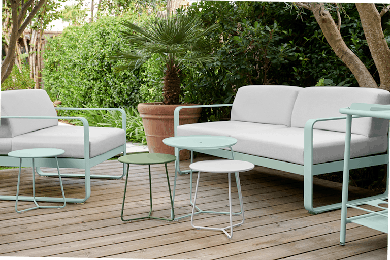 Bellevie outdoor sofa in Ice Mint with Off White cushions behind Cocotte side tables