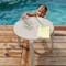 Child reaches from pool for drink off Alize side table in Clay Grey