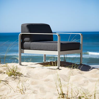 Fermob Bellevie sofa armchair sitting on a sand dune at beach