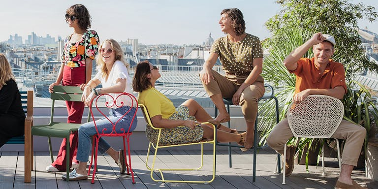 Fermob metal outdoor chairs on a rooftop with people sitting on them