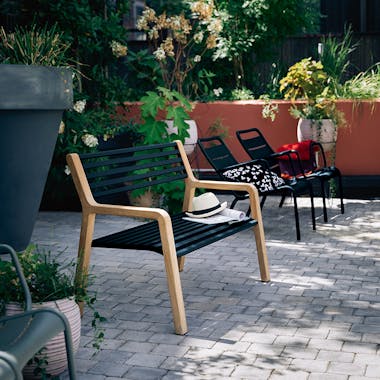 Somerset garden bench with metal slats and wooden ends in hotel courtyard