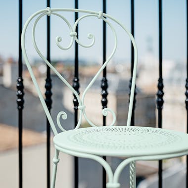 Fermob 1900 French metal chair in front of iron railing