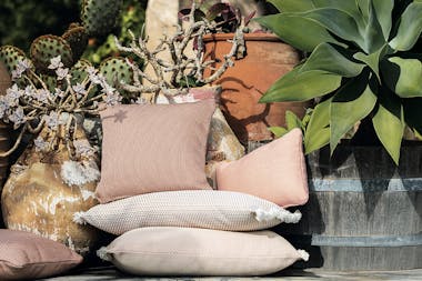 A stack of Fermob Evasion cushions in Atacama