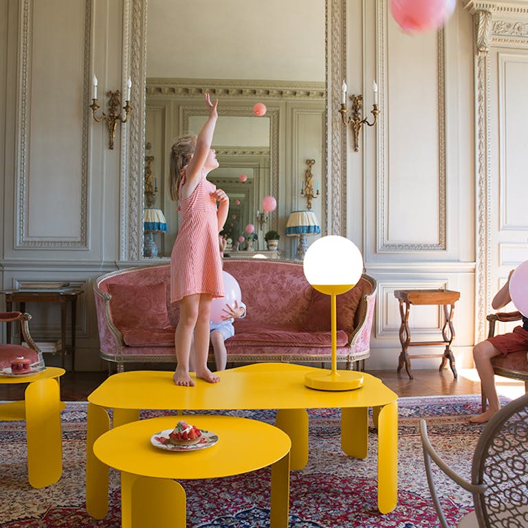 Fermob Mooon! outdoor lamp on yellow table in chateau