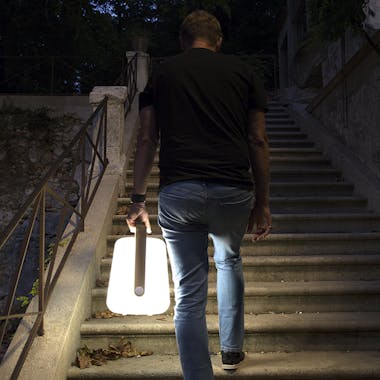Man carries Fermob Balad lamp up steps