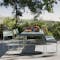 Grey Fermob outdoor dining table with a bench on one side and three chairs on the other