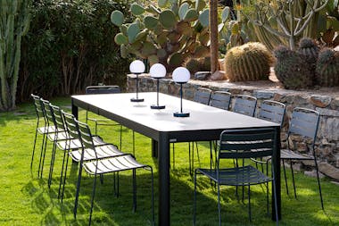 Fermob Ribambelle Extending table with Surprising outdoor chairs in garden