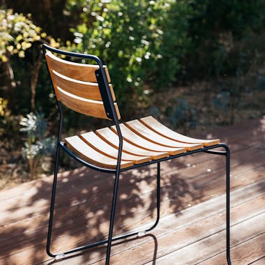 Back of teak & metal outdoor chair from Fermob on deck