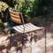 Back of teak & metal outdoor chair from Fermob on deck