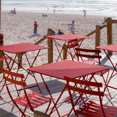 Red cafe folding furniture at a beach