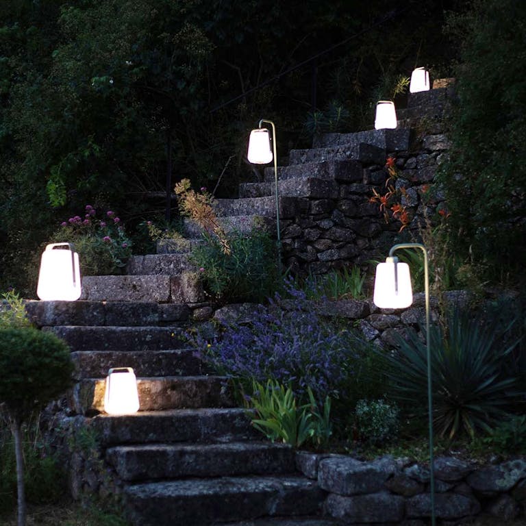 Balad garden lamps and stakes on pathway in evening