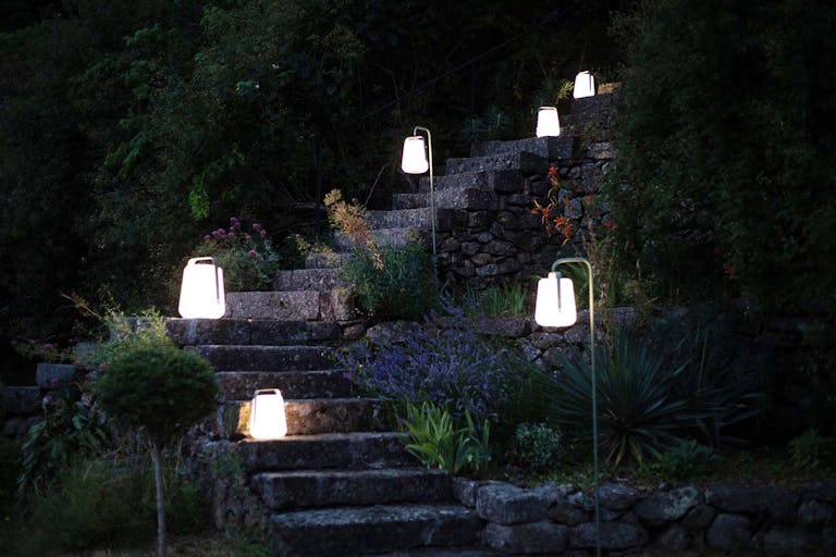 Balad garden lamps and stakes on pathway in evening