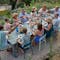 Family gathered around the Ribambelle outdoor extending table from Fermob