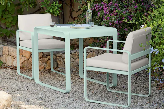 Fermob Bellevie dining armchair with cushions in courtyard