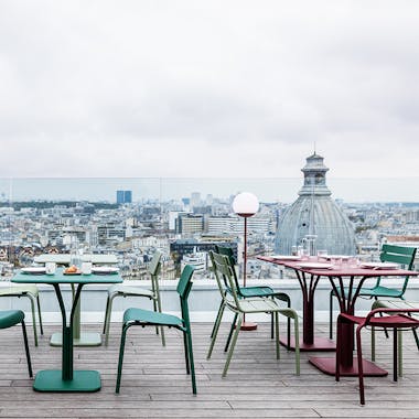Fermob outdoor dining furniture on Parisian roof terrace