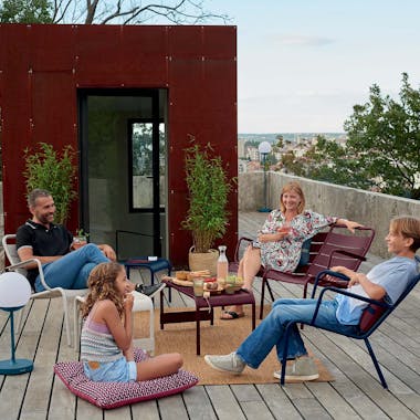 Family gathered together on roof terrace on Fermob Luxembourg outdoor furniture
