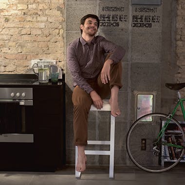 Man sitting on Fermob Bellevie bar stool in apartment