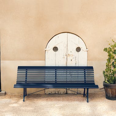Fermob Louisiane 200cm garden bench in Deep Blue in front of old door