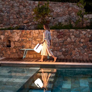 Lady carrying Fermob Balad lamp by pool