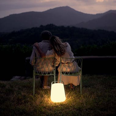 Couple sitting on Fermob Kintbury chairs with Balad outdoor lamp