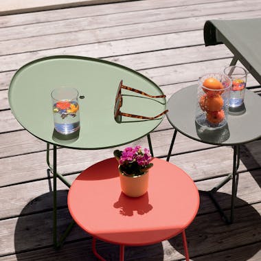 Fermob Cocotte low table and stools nested together with sunlounge