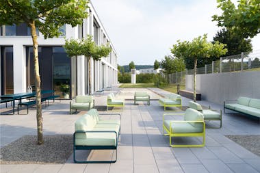 Fermob Bellevie outdoor armchairs and sofas in office courtyard