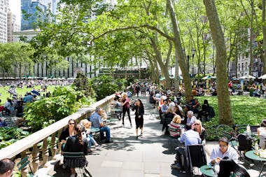 Bryant Park in New York filled with people sitting at Fermob Bistro settings