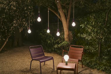 Fermob Aplo lamps suspended from tree in evening light